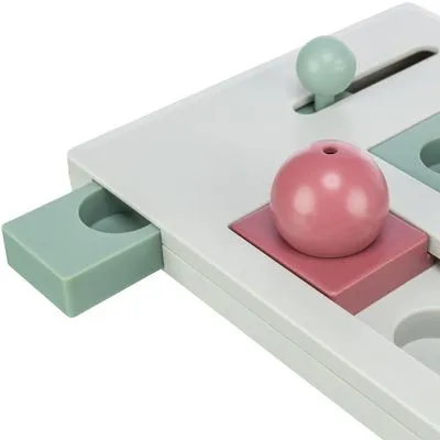 Interactief huisdierenspeelbord van kunststof met verschuifbare groene en roze elementen, ronde knop en uitsparingen voor snacks of beloningen.