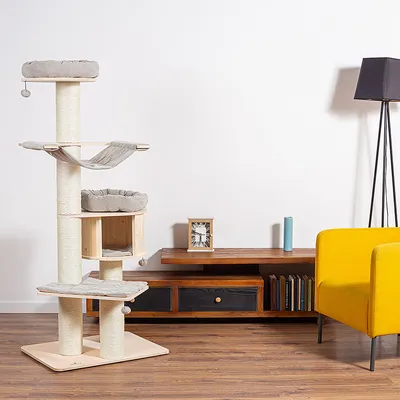 Kratzbaum aus Holz mit mehreren Ebenen, Hängematte, gepolsterten Liegeflächen und Spielbällen. Modernes Design passend zu Wohnmöbeln.
