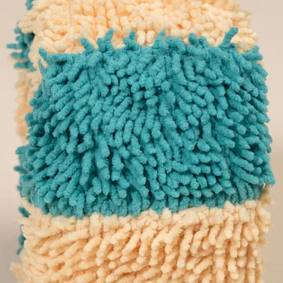Nahaufnahme eines flauschigen Mikrofaser-Materials in beige und türkis, geeignet für Reinigung oder Haustierzubehör.