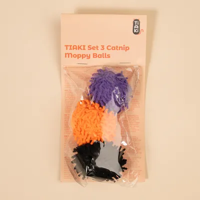 TIAKI set di 3 palline Moppy con catnip nei colori viola, arancione e nero, confezionate in una custodia di plastica trasparente.