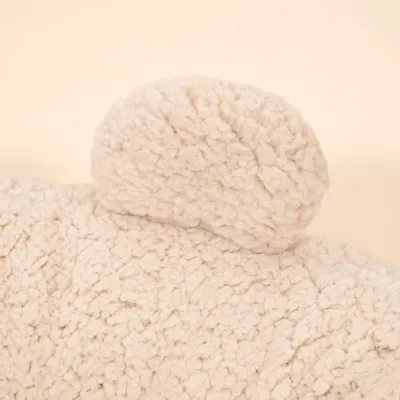 Nahaufnahme eines cremefarbenen, flauschigen Stoffteils mit strukturierter Oberfläche. Nahaufnahme eines cremefarbenen, flauschigen Stoffteils mit strukturierter Oberfläche.