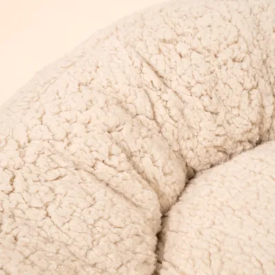 Nahaufnahme eines cremefarbenen, flauschigen Stoffmaterials mit strukturierter Oberfläche. Nahaufnahme eines cremefarbenen, flauschigen Stoffmaterials mit strukturierter Oberfläche.
