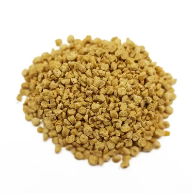 Granulés alimentaires pour animaux, couleur beige, présentés en tas sur fond blanc. Aucun emballage ni marque visible.