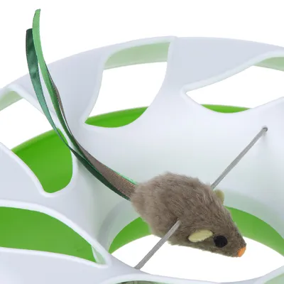 Spielzeugmaus mit braunem Fell und grünen Bändern, befestigt an einem weissen und grünen Kunststoffspielgerät.