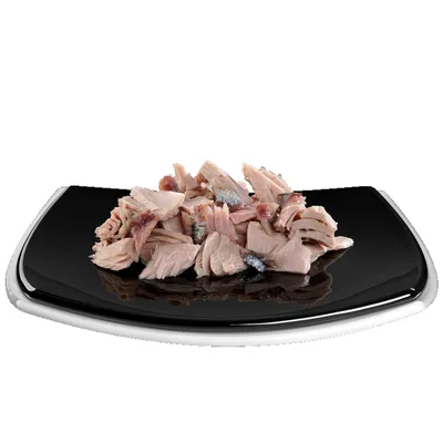 Nahaufnahme von zerkleinertem Thunfisch auf einem schwarzen Teller, präsentiert als Produktbild.