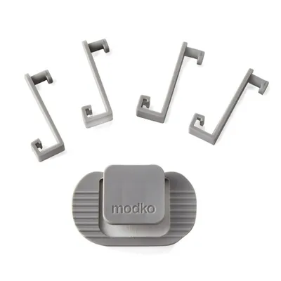 Set van vier grijze kunststof haken en een grijs onderdeel met het opschrift 'modko', alle onderdelen duidelijk zichtbaar.