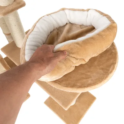 Kaparófa plüss fekvőfelülettel, kéz emeli fel a puha, bézs színű ágyat. Jól látható a textil anyag és a szerkezet részei.
