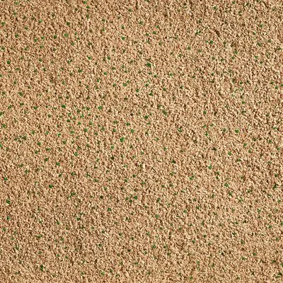 Close-up van kattenbakvulling met beige korrels en kleine groene stukjes, materiaal niet gespecificeerd.