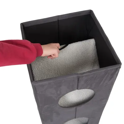 Ruka otvara gornji poklopac sivog, višekatnog mačjeg namještaja s mekanom unutarnjom podstavom.