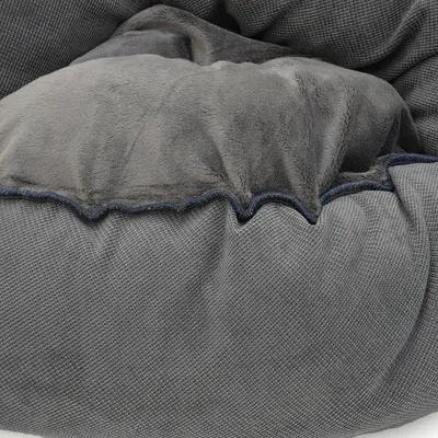 Graues, weiches Material mit strukturierter Oberfläche und Plüschdetails. Nahaufnahme eines Stoffdesigns für Haustierprodukte.