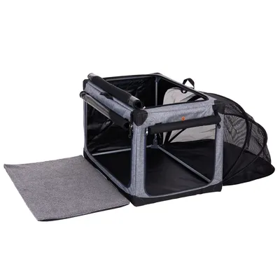 Transportbox aus grauem Stoff mit Netzfenstern, Metallrahmen und herausnehmbarer Matte. Seitlicher Eingang geöffnet.