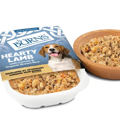 Burns Hearty Lamb with carrots and organic brown rice, developed by veterinarian John Burns. Wet food for adult and senior dogs, shown in packaging and wooden bowl.