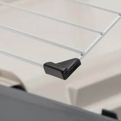 Dettaglio di una griglia in metallo con angolo in plastica nera, parte di un trasportino per animali.