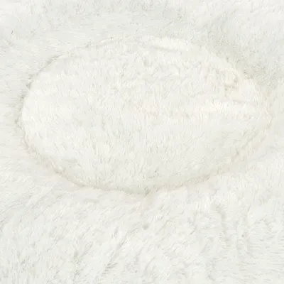 Close-up van wit, pluizig materiaal, mogelijk voor een huisdierenbed of deken.