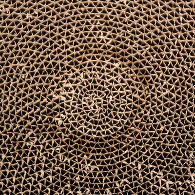Close-up van een spiraalvormige golfkartonstructuur, geschikt voor kraboppervlakken of speelgoed van karton.