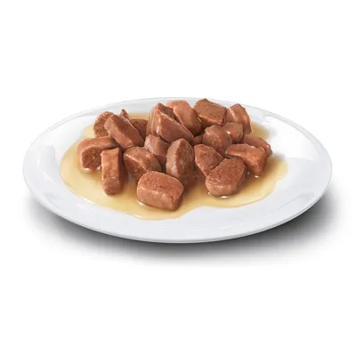 Nahaufnahme von Fleischstücken in Sosse auf einem weissen Teller, dargestellt als Beispiel für die Konsistenz und Präsentation des Produkts.