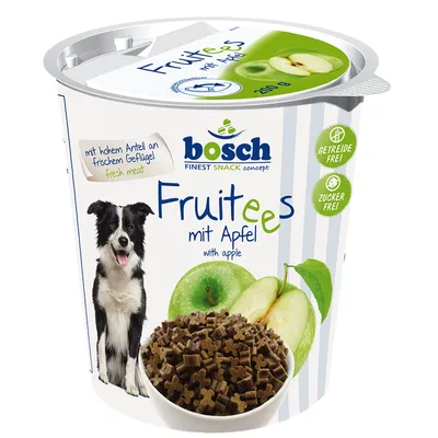 bosch Fruitees mit Apfel with apple, 200 g. Tekst: mit hohem Anteil an frischem Geflügel fresh meat, GETREIDE FREI!, ZUCKER FREI!. Billede af hund, æbler og skål med snacks.