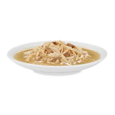 Hvid tallerken med strimlet kød og sovs, serveret som vådfoder til kæledyr. Ingen synlige mærker eller tekst.