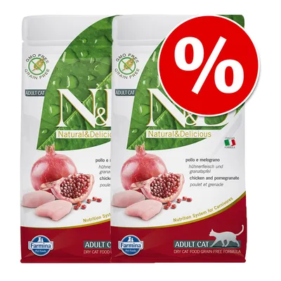 Două pungi Farmina N&D Natural & Delicious Adult Cat, Chicken and Pomegranate, cu etichetă promoțională roșie cu simbol procent. Text vizibil: GMO Free, Grain Free, Italian Formula.
