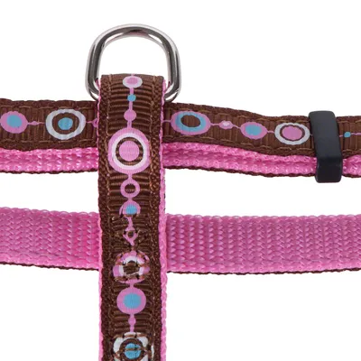 Pettorina rosa per cani con accenti marroni e motivo a cerchi colorati, anello in metallo per il guinzaglio visibile.