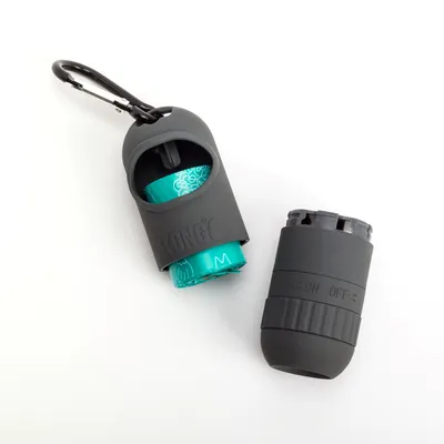 Pojemnik KONG z karabińczykiem na woreczki na odchody, widoczna rolka turkusowych woreczków M. Drugi pojemnik z napisem ON OFF. Materiał: plastik.