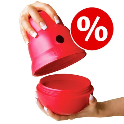Juguete interactivo rojo de plástico KONG abierto, sostenido por dos manos. Símbolo de porcentaje en círculo rojo visible en la esquina superior derecha.