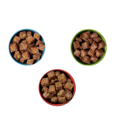 Three bowls containing brown, cube-shaped food pieces with visible vegetable chunks, shown from above to display product texture and ingredients.