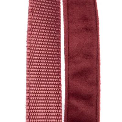 Närbild av två material: till vänster strukturerat tyg i rosa, till höger mjukt, sammetliknande material i mörkrött.