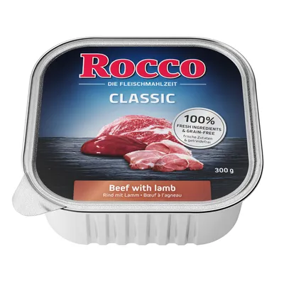 Embalagem de comida húmida Rocco Classic, 300 g, com texto visível: 'Beef with lamb', '100% fresh ingredients & grain-free'. Imagem de carne de vaca e borrego na tampa.