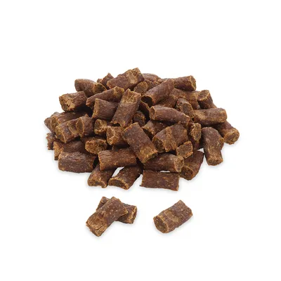 Ein Haufen brauner, röhrenförmiger Hundesnacks aus getrocknetem Fleisch, ohne sichtbare Verpackung oder Markenkennzeichnung.