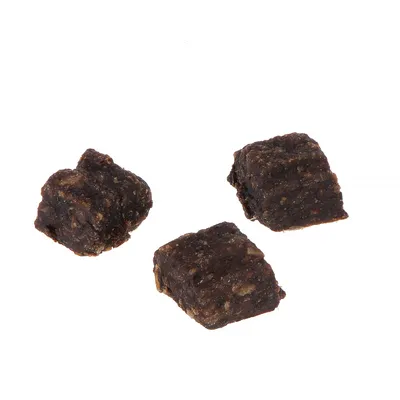 Három sötétbarna, kocka alakú snack szemcsés textúrával.