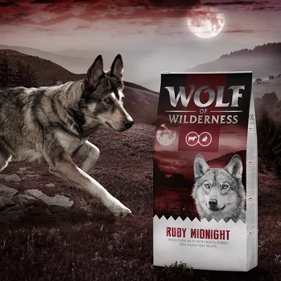 Confezione di crocchette Wolf of Wilderness Ruby Midnight, testo visibile: 'Fresh pork meat with beef & rabbit, 100% grain-free recipe', immagine di lupo su sfondo naturale.