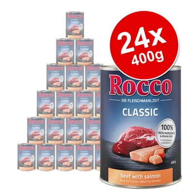 Rocco Classic Beef with salmon, 24 x 400g cans. Label shows 100% fresh ingredients & grain-free. Large can in front, pyramid of cans behind. Visible text in German and English.