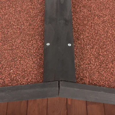 Dettaglio di una copertura del tetto rossa con cornice in legno nera e due viti visibili.