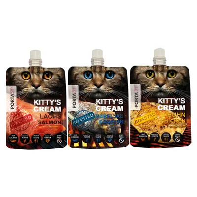 Kolme PORTA21 Kitty's Cream -annospussia: lohi (LACHS SALMON), turska (KABELJAU CODFISH) ja kana (HUHN CHICKEN). Pakkauksissa tekstit roasted, sugar-free, grain free, source of omega.