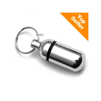 Capsule métallique avec anneau porte-clés, bande noire visible. Coin supérieur droit : texte anglais « Top Seller » sur fond orange.