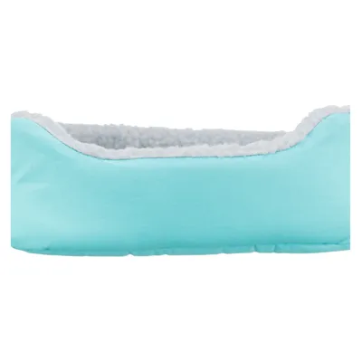 Lichtblauw bed met zachte, witte binnenvulling. Rechthoekige vorm zichtbaar.