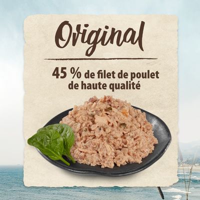 Original, 45 % de filet de poulet de haute qualité. Assiette de nourriture humide avec morceaux visibles et une feuille d’épinard à côté.