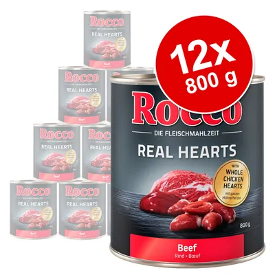 Lot de 12 boîtes Rocco Real Hearts Beef 800 g, texte visible : 'with whole chicken hearts', image de viande sur l’étiquette. Marque et variété bien lisibles.