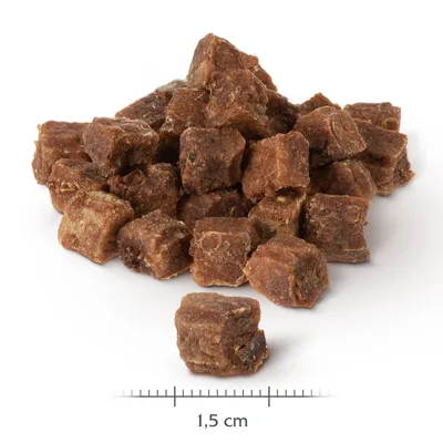 Bruna, kubformade snacks med en storlek på 1,5 cm. Detaljvy av textur och mått.