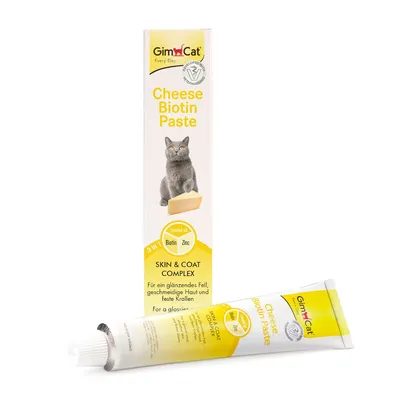 GimCat Cheese Biotin Paste, tube et boîte visibles. Texte : Cheese Biotin Paste, Skin & Coat Complex, Linseed oil, Biotin, Zinc. Image d’un chat gris avec un morceau de fromage.