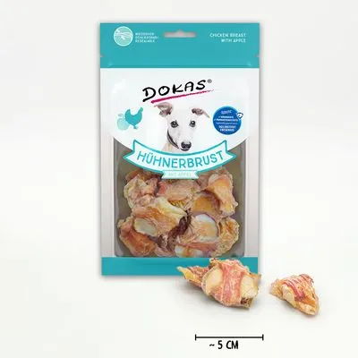 Zak Dokas Hühnerbrust mit Apfel, zichtbare stukjes kipfilet met appel, maatindicatie ~5 cm. Tekst op verpakking deels in het Duits en Engels.