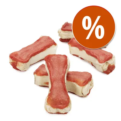 Snack em forma de osso para cães, com camada exterior vermelha e interior claro. Círculo laranja com símbolo de percentagem (%) indica promoção ou desconto.
