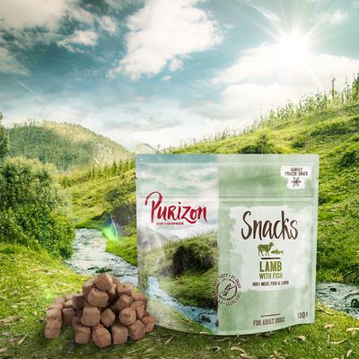 Purizon Snacks Lamb with Fish, 100% meat, fish & liver, for adult dogs, 100 g. Opakowanie i kawałki przysmaku widoczne na tle natury.