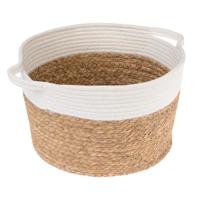 Rund korg av flätat naturmaterial med vit tygkant och två integrerade handtag.