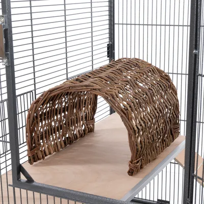 Geflochtener Tunnel aus Naturholz auf einer Holzplattform in einem Metallkäfig. Geeignet als Versteck oder Spielplatz für Kleintiere. Geflochtener Tunnel aus Naturholz auf einer Holzplattform in einem Metallkäfig. Geeignet als Versteck oder Spielplatz für Kleintiere.