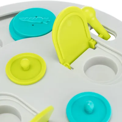 Spielzeug mit gelben und blauen Klappen sowie runden Vertiefungen, geeignet für interaktives Spielen oder Belohnungssuche.