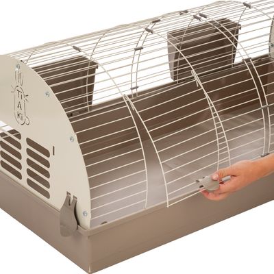 Kleintierkäfig mit Metallgitter und brauner Kunststoffwanne. Hand zeigt die Bedienung des Verschlussmechanismus am Gitter.