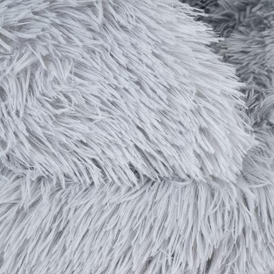 Detailní záběr na šedou umělou kožešinu s dlouhými, měkkými vlákny.