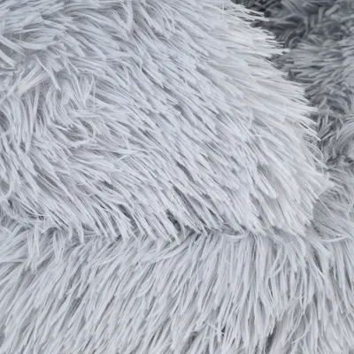 Detailní záběr na šedou umělou kožešinu s dlouhými, měkkými vlákny.